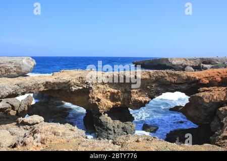 Arco di roccia o formazione di ponte naturale di calcare corallo sulla costa marina dell'isola di Aruba. Caraibi olandesi Foto Stock