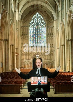 Il Revd Michael Smith, il canonico Pastore della cattedrale di York Minster, prova un servizio digitale di Evensong all'interno della cattedrale, mentre il governo si muove verso l'introduzione di misure per portare il paese fuori dalla chiusura. Foto Stock