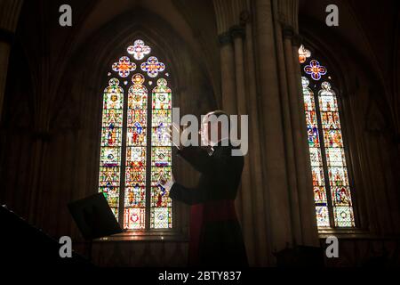 Il Revd Michael Smith, il canonico Pastore della cattedrale di York Minster, prova un servizio digitale di Evensong all'interno della cattedrale, mentre il governo si muove verso l'introduzione di misure per portare il paese fuori dalla chiusura. Foto Stock