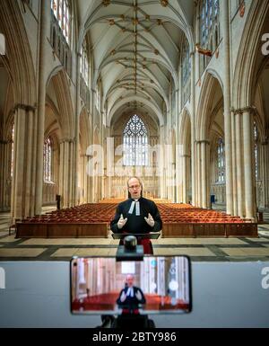 Il Revd Michael Smith, il canonico Pastore della cattedrale di York Minster, prova un servizio digitale di Evensong all'interno della cattedrale, mentre il governo si muove verso l'introduzione di misure per portare il paese fuori dalla chiusura. Foto Stock