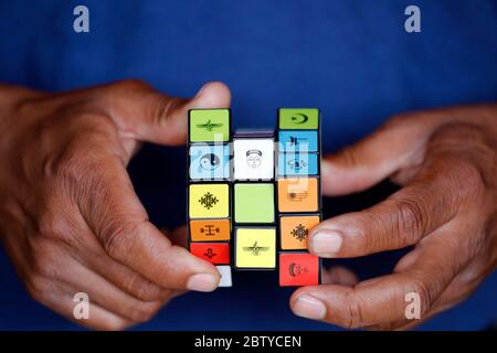 Uomo africano con cubo di Rubik con simboli religiosi, concetto di dialogo interreligioso e interreligioso, Madagascar, Africa Foto Stock