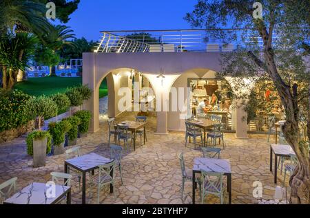 Zona pranzo a schiera al tramonto presso il Marbella Beach Hotel, Corfu, Grecia. Foto Stock