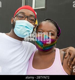 Detroit, Michigan - i volontari che indossano maschere facciali posano per una foto mentre distribuiscono il cibo libero in un quartiere a basso reddito durante il coronavirus pa Foto Stock