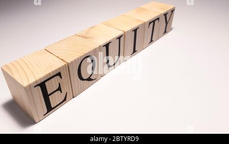 Parola di equità scritta in cubo di legno. Primo piano. Foto Stock