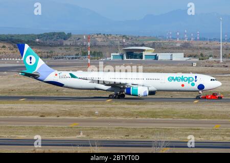 Evelop Airlines Airbus A330 trainato da un camion all'aeroporto Barajas di Madrid in Spagna. AEROMOBILE A330-300 EC-LXA. Compagnia aerea spagnola a basso costo. Foto Stock