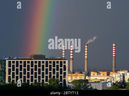 Camini delle centrali elettriche e arcobaleno luminoso contro il cielo buio dopo la tempesta su un complesso industriale in ambiente urbano, Sofia Bulgaria, Europa orientale, UE Foto Stock