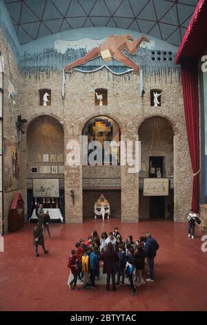 Il gruppo di visitatori rimane esattamente sulla tomba senza segno del pittore surrealista spagnolo Salvador Dalí nella sala principale del Teatro e Museo Salvador Dalí a Figueres, Catalogna, Spagna. Sullo sfondo è visibile il dipinto di Salvador Dalí intitolato 'Lincoln in Dalivision'. Foto Stock