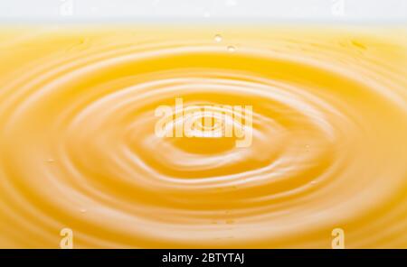 le onde dopo alcune gocce di succo d'arancia. Foto Stock