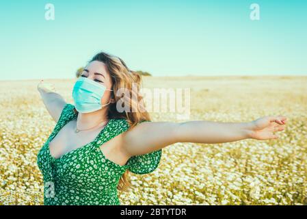 donna con maschera medica godendo della libertà nel paese Foto Stock