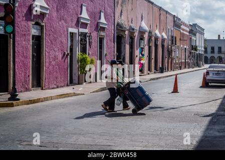 Spazzatrici di strada in strada tipica con belle case dipinte di pastello, Valladolid, Yucatan, Messico Foto Stock