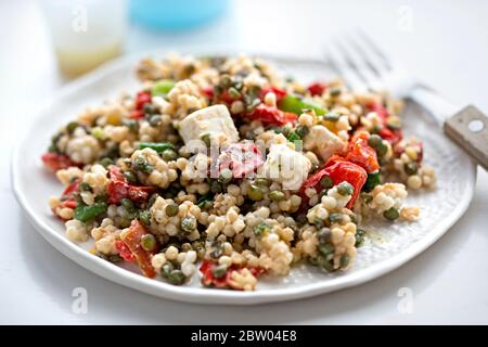 Insalata couscous gigante con formaggio feta, lenticchie, peperoni rossi e condimento vinaigrette Foto Stock