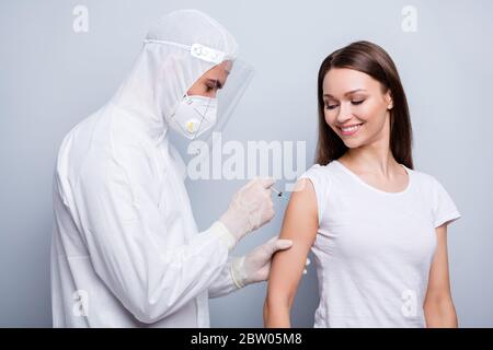 Foto di allegro paziente donna ragazzo esperto virologia iniettare spalla covid antidoto vaccino sperimentale indossare maschera cappuccio uniforme plastica viso Foto Stock