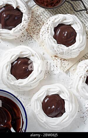 Meringa nidi con salsa di cioccolato Foto Stock