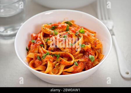 Tagliatelle di pollo con salsa di pomodoro e prezzemolo Foto Stock