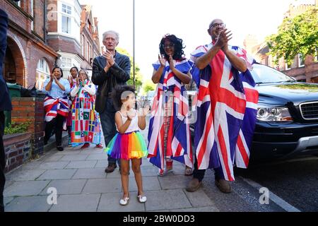 Neighbours of Annemarie Plas, 36, un cittadino olandese che vive nel sud di Londra e ha creato il Clap settimanale delle 20:00 per i nostri carceri, a Londra meridionale si unisce agli applausi per salutare gli eroi locali durante il Clap nazionale di giovedì per i carceri per riconoscere e sostenere i lavoratori e gli assistenti della NHS che combattono la pandemia del coronavirus. Foto Stock