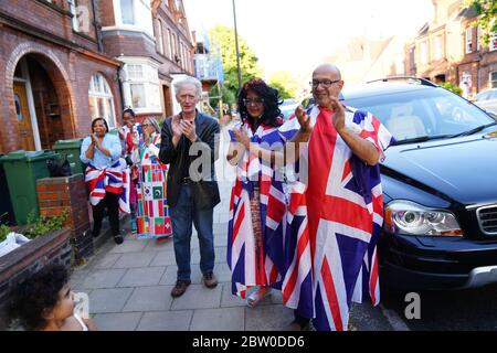 Neighbours of Annemarie Plas, 36, un cittadino olandese che vive nel sud di Londra e ha creato il Clap settimanale delle 20:00 per i nostri carceri, a Londra meridionale si unisce agli applausi per salutare gli eroi locali durante il Clap nazionale di giovedì per i carceri per riconoscere e sostenere i lavoratori e gli assistenti della NHS che combattono la pandemia del coronavirus. Foto Stock