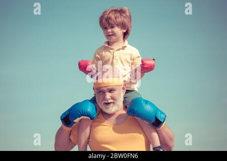Combattente sano nonno e nipote con guanti di pugilato. Nonno e nipote che fanno l'addestramento di boxe in mattina Foto Stock