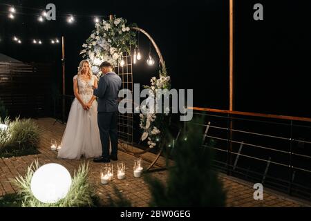 Sposo che dice un giuramento alla sposa alla cerimonia nuziale nella sera. Buona mariage Foto Stock