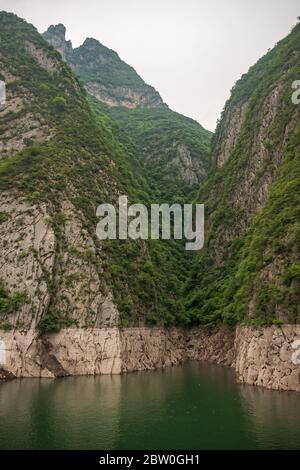 Wushan, Hubei, Cina - 7 maggio 2010: Gola WU nel fiume Yangtze. La divisione della costa forma un ripido e breve canyon tra le verdi pareti di montagna coperte sotto sil Foto Stock