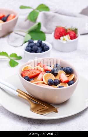 Cereali dolci e minuscoli pancake con frutti di bosco Foto Stock