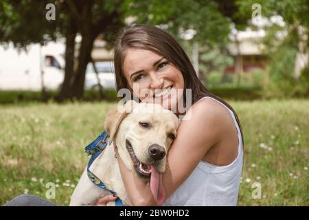 la ragazza abbraccia il suo cane stretto, nel parco Foto Stock