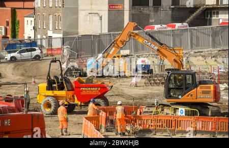 Pontypridd, Galles - Maggio 2018: Escavatore che lavora al progetto di rigenerazione della paglia vale riempiendo di terra un dumper. Foto Stock