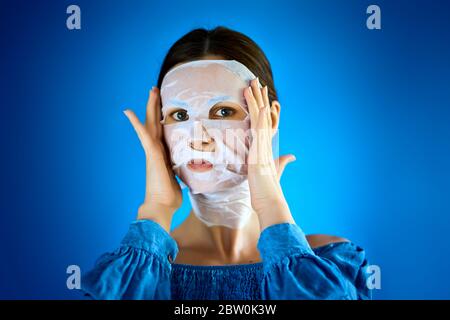 donna mostra come applicare una maschera di bellezza al tuo viso Foto Stock