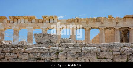 L'Acropoli di Atene, il punto di riferimento più importante della Grecia. Parte superiore del tempio del Partenone, facciata vista laterale antiche rovine, cielo blu sfondo in primavera sole giorno. Foto Stock