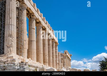 L'Acropoli di Atene, il punto di riferimento più importante della Grecia. Tempio Partenone facciata vista laterale, antiche rovine del tempio, cielo blu sfondo in primavera sole giorno. Foto Stock