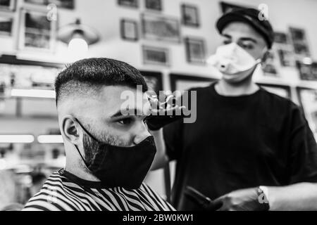 Taglio di capelli in quarantena. Taglio di capelli in maschere dal virus. Capelli e cure sanitarie. Foto Stock