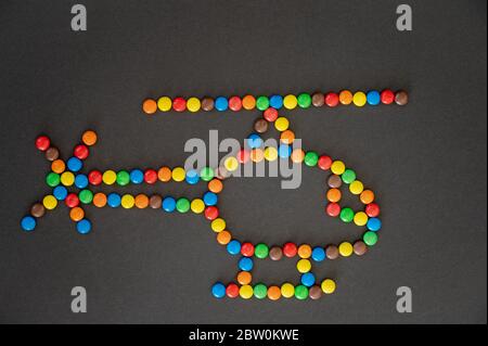 Forma in elicottero fatta di caramelle colorate su sfondo nero Foto Stock