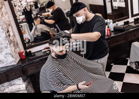 Taglio di capelli in quarantena. Taglio di capelli in maschere dal virus. Capelli e cure sanitarie. Foto Stock