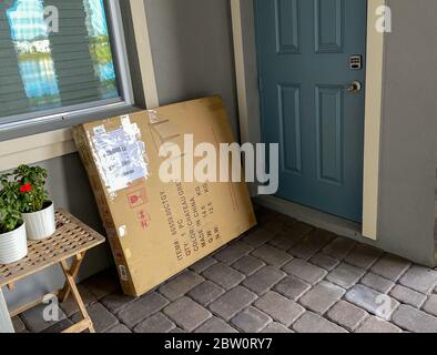 Una scatola di cartone sulla porta di una casa di fronte a una porta. Foto Stock