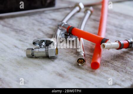 Installazione tubo di collegamento nuovo miscelatore acqua rubinetto su lavello cucina una nuova casa Foto Stock