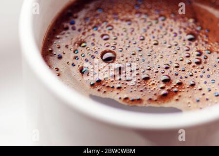 Primo piano Grande tazza di caffè al mattino con la schiuma di latte,  piatti eleganti, still life concettuale nella retroilluminazione del sole  brillante Foto stock - Alamy