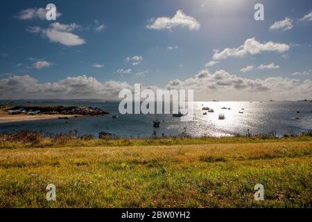 Diverse barche ormeggiate nella baia di Weymouth vicino ad una piccola spiaggia di sabbia in una calda mattina soleggiata in estate Foto Stock