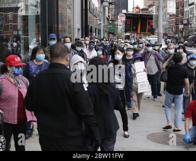 New York, Stati Uniti. 28 Maggio 2020. I clienti della TD Bank indossano maschere protettive mentre aspettano in fila per ore per entrare in una filiale cinese a New York City giovedì 28 maggio 2020. Il totale di morte COVID-19 degli Stati Uniti ora top 100,000. Foto di John Angelillo/UPI Credit: UPI/Alamy Live News Foto Stock