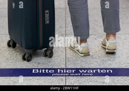 Lipsia, Germania. 27 maggio 2020. Un viaggiatore attende dietro un pennarello presso uno stand informativo della stazione ferroviaria centrale di Lipsia. Con più dispenser per mani disinfettanti, più frequenti pulizie e luce anti-virus, Deutsche Bahn vuole prepararsi per il crescente traffico di passeggeri nella crisi della corona nelle stazioni. Con le nuove macchine per la pulizia, le superfici potrebbero essere disinfettate più estesamente che in passato. Credit: Jan Woitas/dpa-Zentralbild/dpa/Alamy Live News Foto Stock