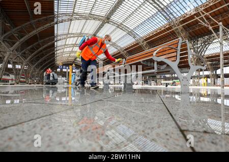 Lipsia, Germania. 27 maggio 2020. Un dipendente del DB pulisce e disinfetta un'area salotto della stazione centrale di Lipsia. Con più dispenser per mani disinfettanti, più frequenti pulizie e luce anti-virus, Deutsche Bahn vuole prepararsi per il crescente traffico di passeggeri nella crisi della corona nelle stazioni. Con le nuove macchine per la pulizia, le superfici potrebbero essere disinfettate più estesamente che in passato. Credit: Jan Woitas/dpa-Zentralbild/dpa/Alamy Live News Foto Stock