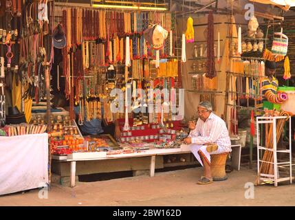 Un uomo che vende gioielli artificiali nel suo negozio. Foto Stock