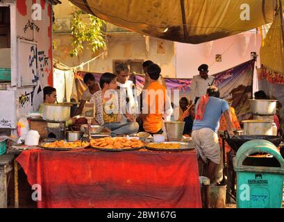 Venditori ambulanti che vendono kachori, uno spuntino indiano nel suo negozio. Foto Stock