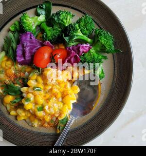 Farina di mais indonesiana grattugiata con broccoli, pomodori e cavolo ​​purple a fette servito su piatto Foto Stock