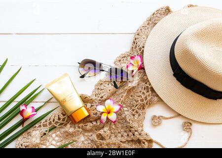 crema solare spf50 cosmetici cura della salute per la pelle viso con crochet, fiori frangipani, occhiali da sole, cappello e foglia di cocco di stile di vita donna relax Foto Stock