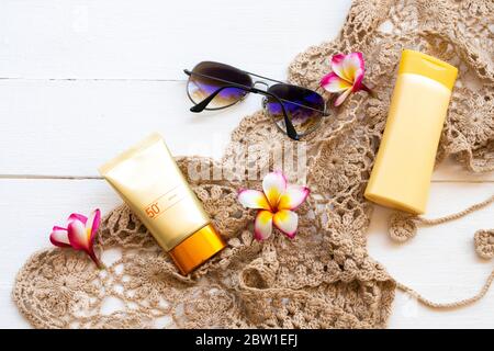 crema solare spf50 cosmetici cura della salute per la pelle viso con crochet, fiori frangipani, occhiali da sole, lozione corpo di stile di vita donna relax in estate Foto Stock