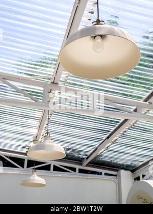 Moderne plafoniere appese sotto il tetto trasparente, stile verticale. Foto Stock