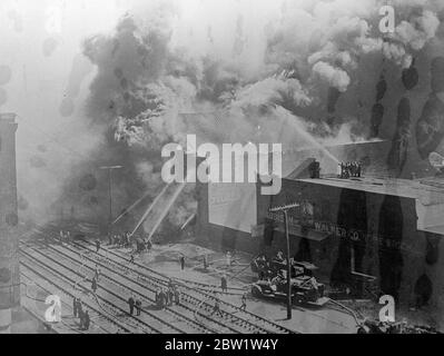 Enorme ascensore di grano brillare a Philadelphia. Un incendio enorme distrusse un elevatore di cereali e un magazzino a Philadelphia, Pennsylvania. Ma il calore straordinario del fieno e della paglia che bruciavano ha costretto i vigili del fuoco a tornare più volte e molti di loro sono stati superati. Foto: Volumi di fumo denso che si innalzano da un edificio in fiamme mentre i vigili del fuoco lottavano per sottometterle. 11 aprile 1937 Foto Stock