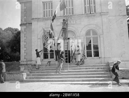 Villaggio francese di decorato per le nozze del duca di Windsor. Con le bandiere inglesi, americane e francesi che dominano il piccolo villaggio di Monts vicino al Chateau de Cande è in fase di decorazione per il matrimonio domani (Giovedi) dei figli di Windsor e la signora Wallis Warfield (ex Simpson). Spettacoli fotografici, regia bandiere su un municipio di Monts, vicino al Chateau de Cande 2 giugno 1937 Foto Stock