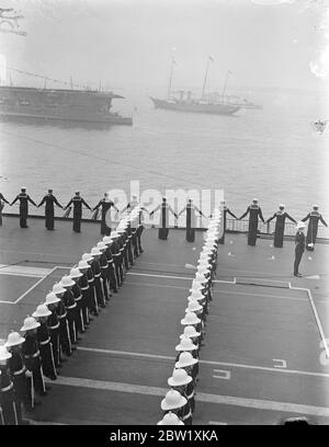 Il King esamina la flotta di Spihead. A bordo dello yacht reale, 'Victoria and Albert', il Re passò attraverso la linea di 5 miglia di 160 navi da guerra e mercantili quando fece la sua revisione di coronazione della Marina Britannica e Mercantile Marine a Spihead. Sono state riviste quasi 300 navi, di cui 17 provenienti dalle flotte straniere. Foto mostra, la Royal yacht 'Victoria and Albert' immagine fatta dalla portaerei HMS glorioso come l'equipaggio vestito nave come il re yacht passato. 20 maggio 1937 Foto Stock