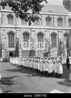 I distaccamenti volontari di aiuto tiene la Parata della Chiesa nella Cattedrale di Winchester. Le infermiere del distaccamento volontario assistito sono nel campo estivo a Sparsholt, Hampshire, frequentano la Parata della Chiesa alla Cattedrale di Winchester. Le infermiere sono state ispezionate da Connell F. D. Howell. Spettacoli fotografici: Infermieri che marciano fuori dalla cattedrale. 6 giugno 1937 Foto Stock