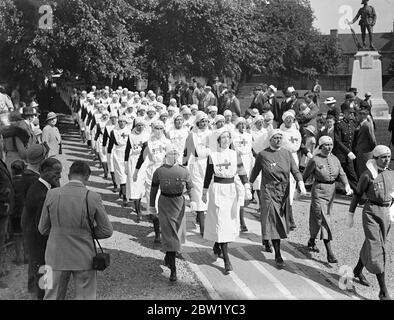 I distaccamenti volontari di aiuto tiene la Parata della Chiesa nella Cattedrale di Winchester. Le infermiere del distaccamento volontario assistito sono nel campo estivo a Sparsholt, Hampshire, frequentano la Parata della Chiesa alla Cattedrale di Winchester. Le infermiere sono state ispezionate da Connell F. D. Howell. Spettacoli fotografici: Infermieri che marciano fuori dalla cattedrale. 6 giugno 1937 Foto Stock